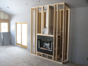 prefabricated wood burning fireplace surrounded by wood beams