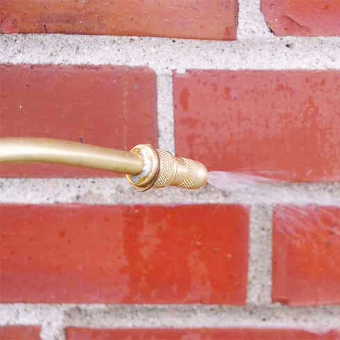 Water repellent being applied to nice red bricks with wand.